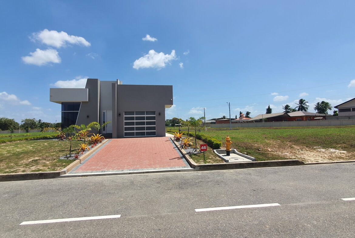 Modern Freeport home with floor-to-ceiling windows and red brick driveway.