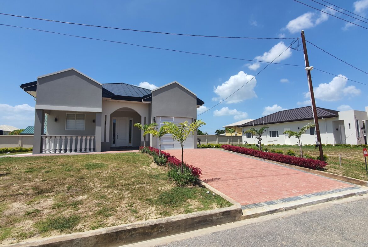 Modern Freeport home with red brick driveway and landscaping.