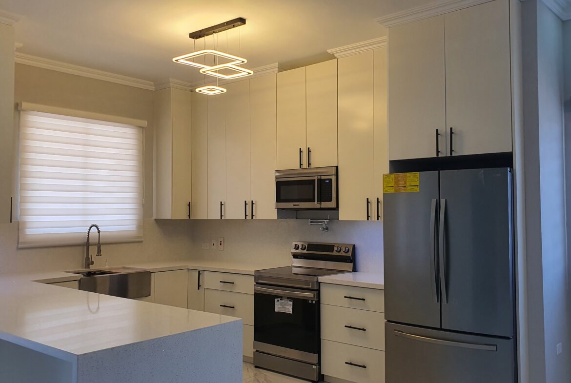 Modern kitchen with white cabinets, stainless steel appliances, and breakfast bar in a Freeport home.