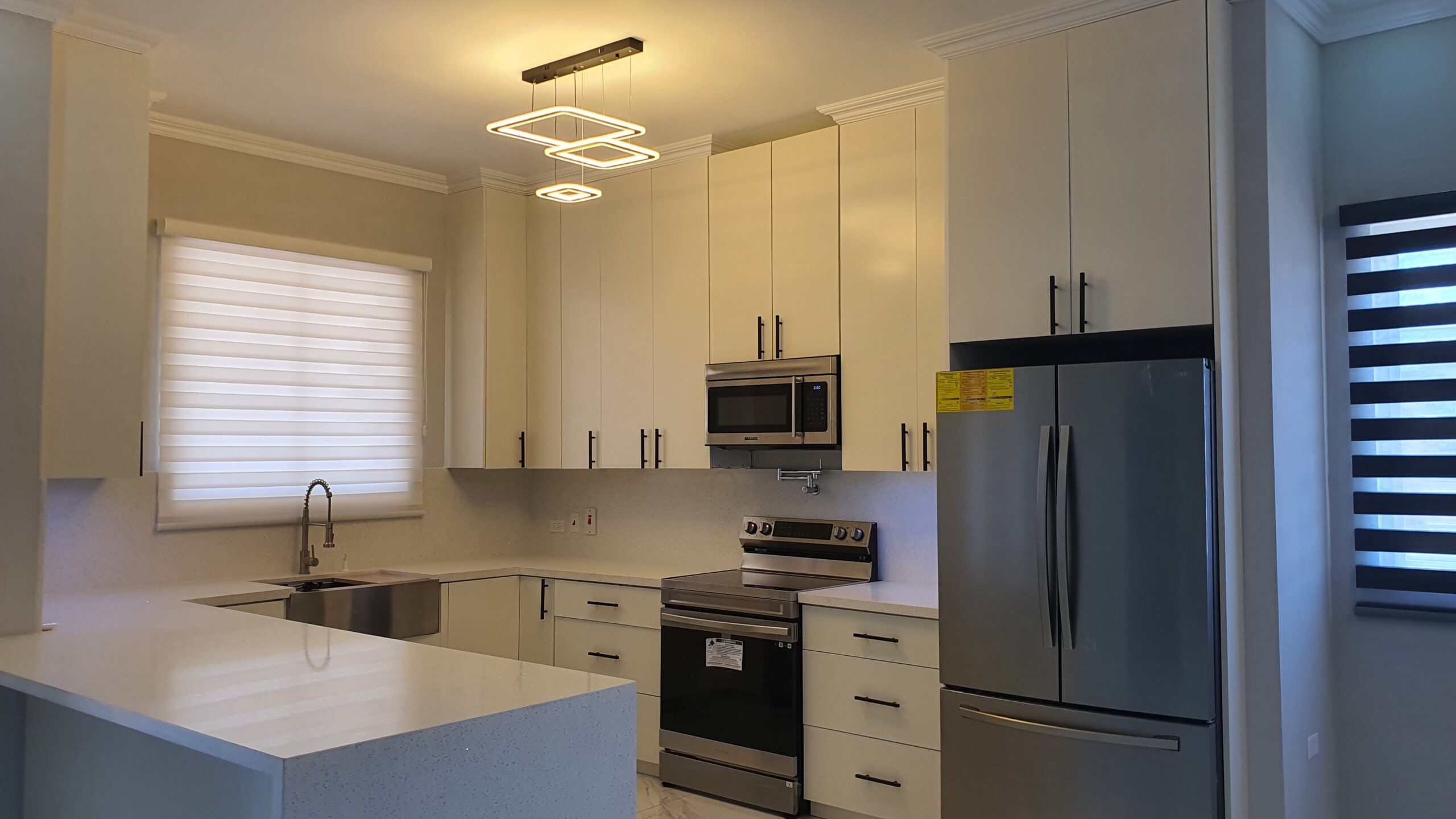 Modern kitchen with white cabinets, stainless steel appliances, and breakfast bar in a Freeport home.