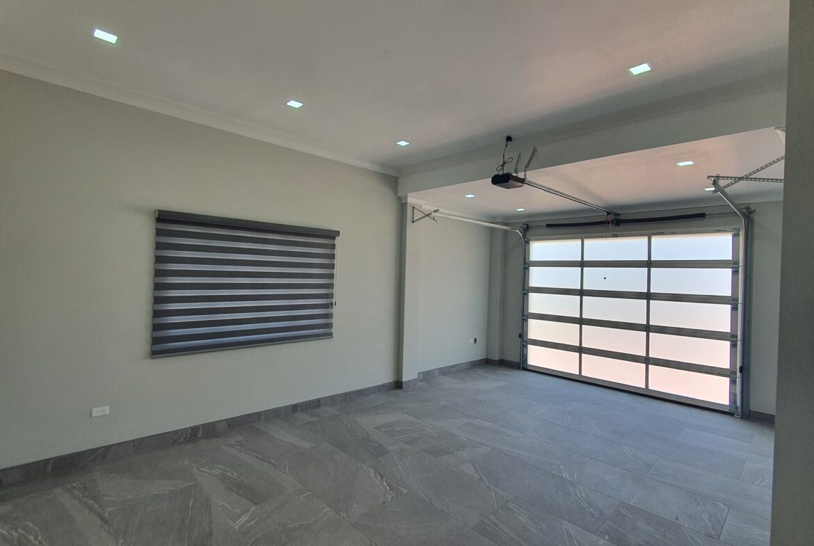 Modern two-car garage with remote-controlled rolling door in a Freeport home at Lima Estates.