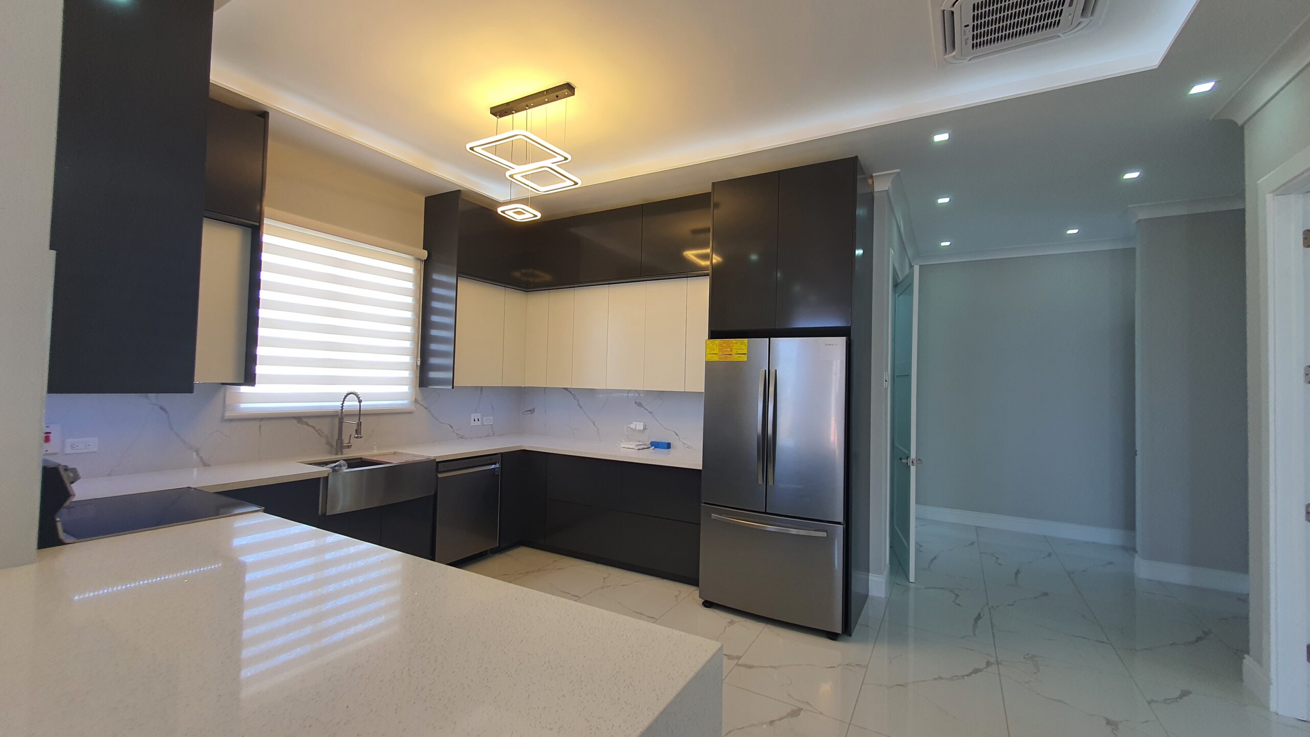 Modern kitchen with white cabinets, stainless steel appliances, and breakfast bar in a Freeport home.