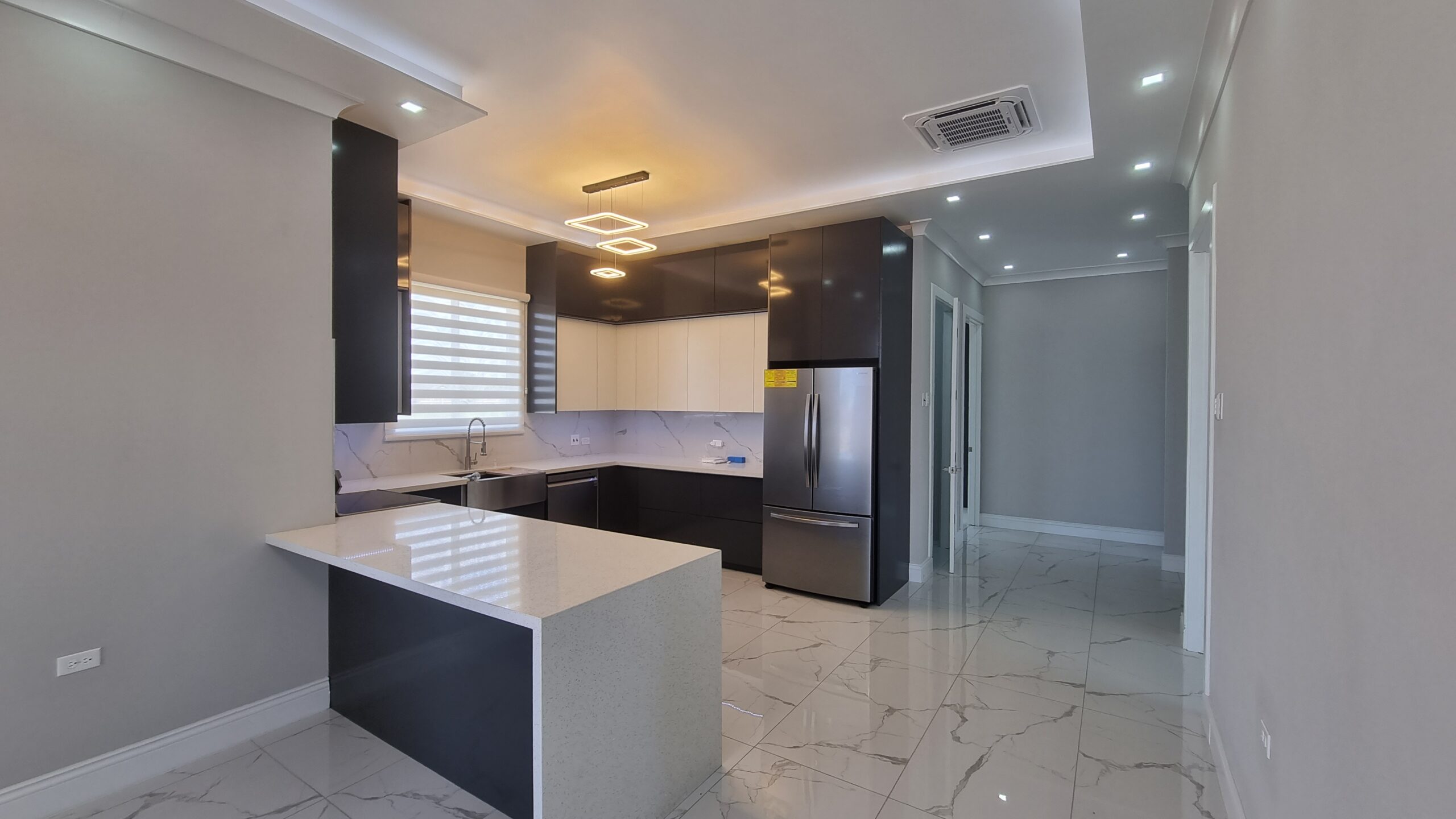 Modern kitchen with white and dark wood cabinets, stainless steel appliances, and breakfast bar in a Freeport home.
