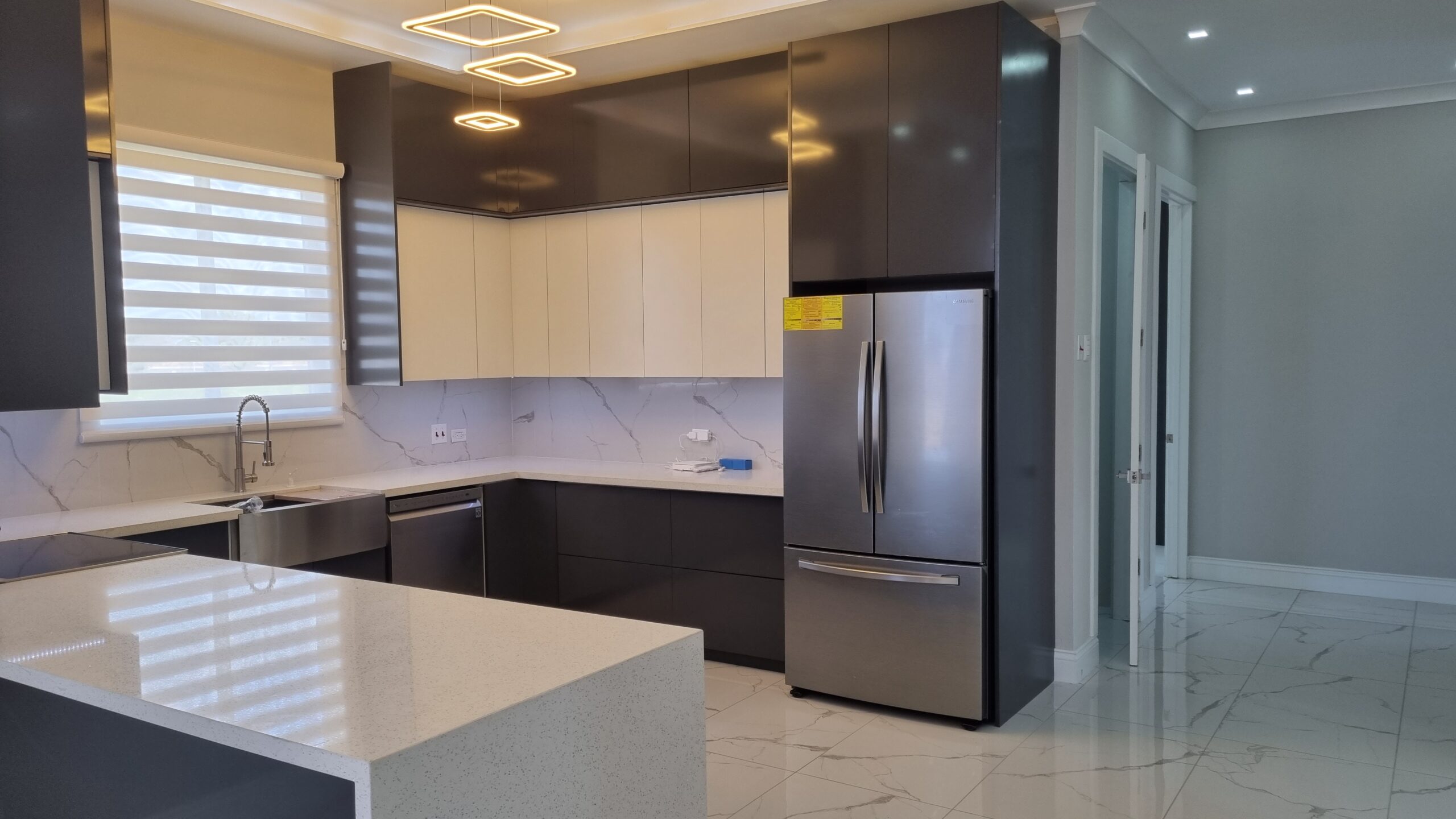 Modern kitchen with white and dark wood cabinets, stainless steel appliances, and breakfast bar in a Freeport home.