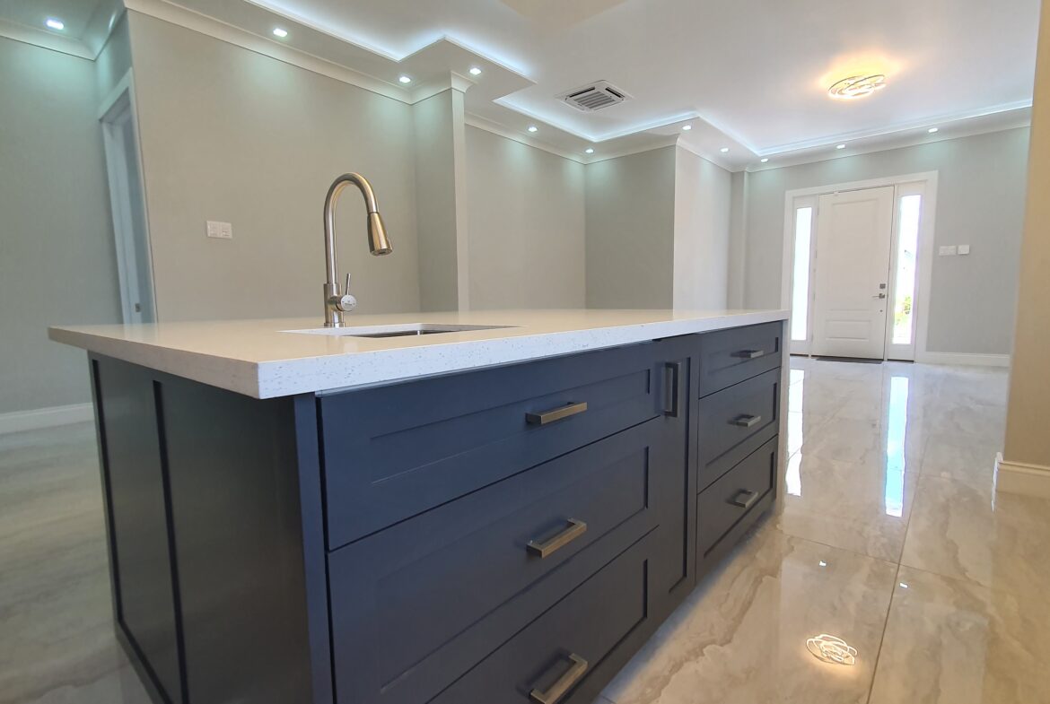 Modern kitchen island with built-in sink and faucet in a Freeport home.