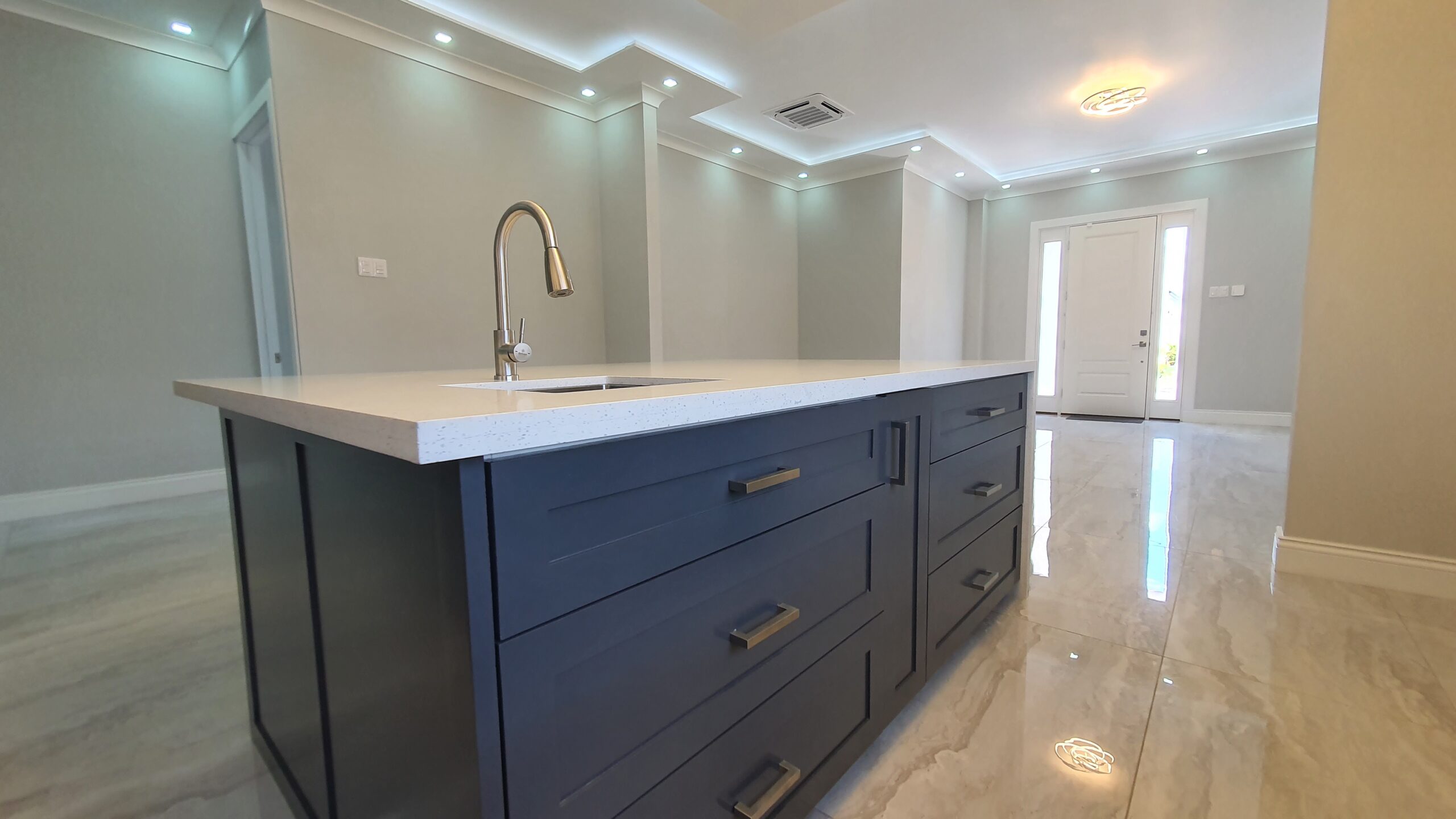 Modern kitchen island with built-in sink and faucet in a Freeport home.