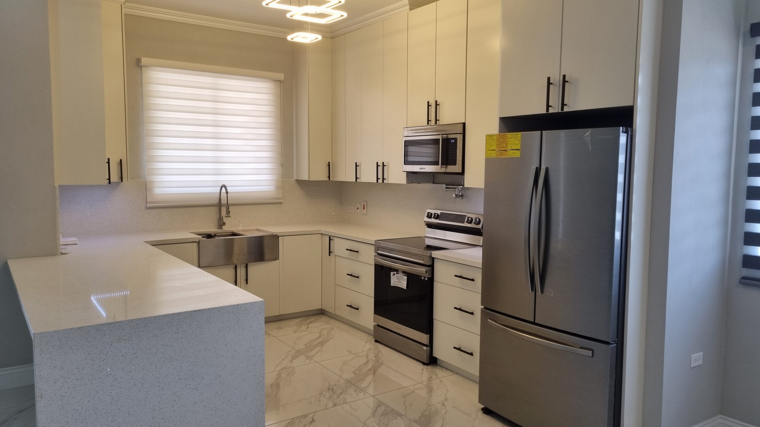 Modern kitchen with stainless steel appliances, white cabinets, and granite countertops in a Freeport home.
