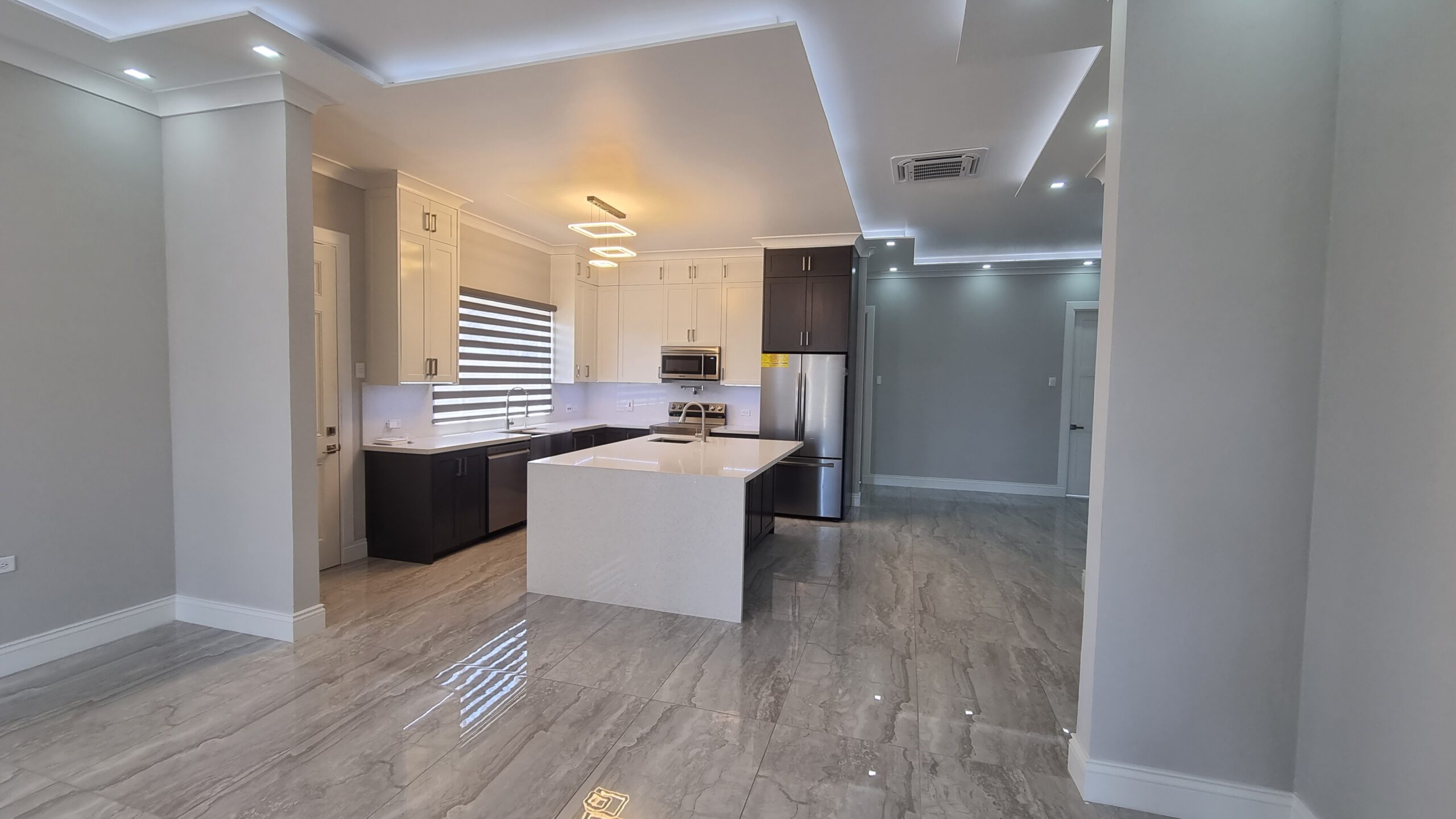 Modern kitchen island with butcher block countertop, stainless steel drawers and cabinets in a Freeport home.