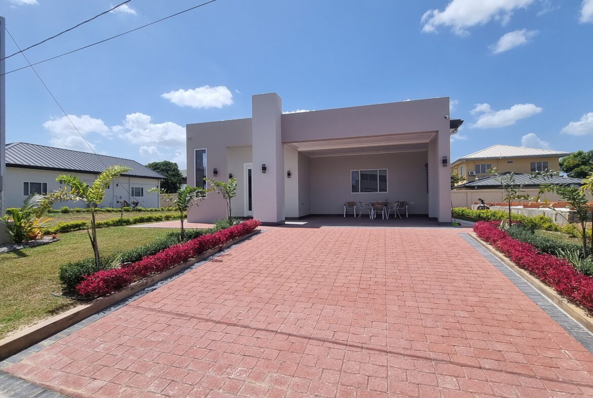 Modern Freeport home with red brick driveway and landscaped flower beds.