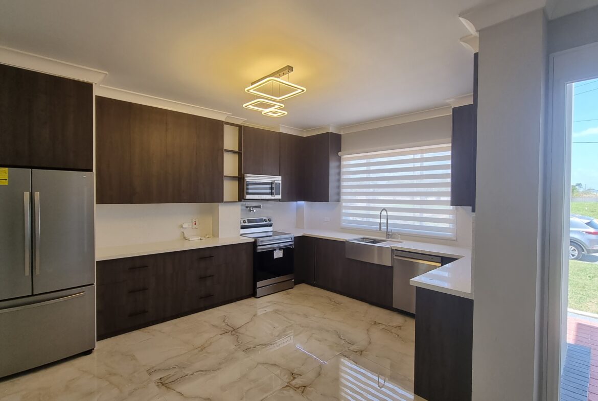Modern kitchen with dark wood cabinets, stainless steel appliances, and granite countertops in a Freeport home.