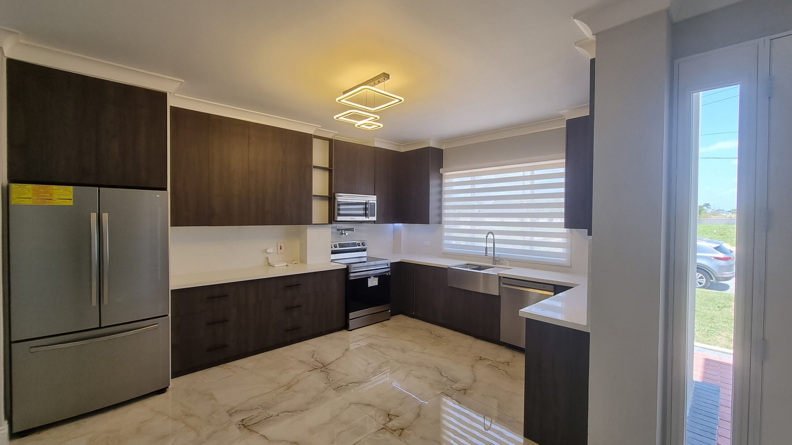 Modern kitchen with dark wood cabinets, stainless steel appliances, and granite countertops in a Freeport home.