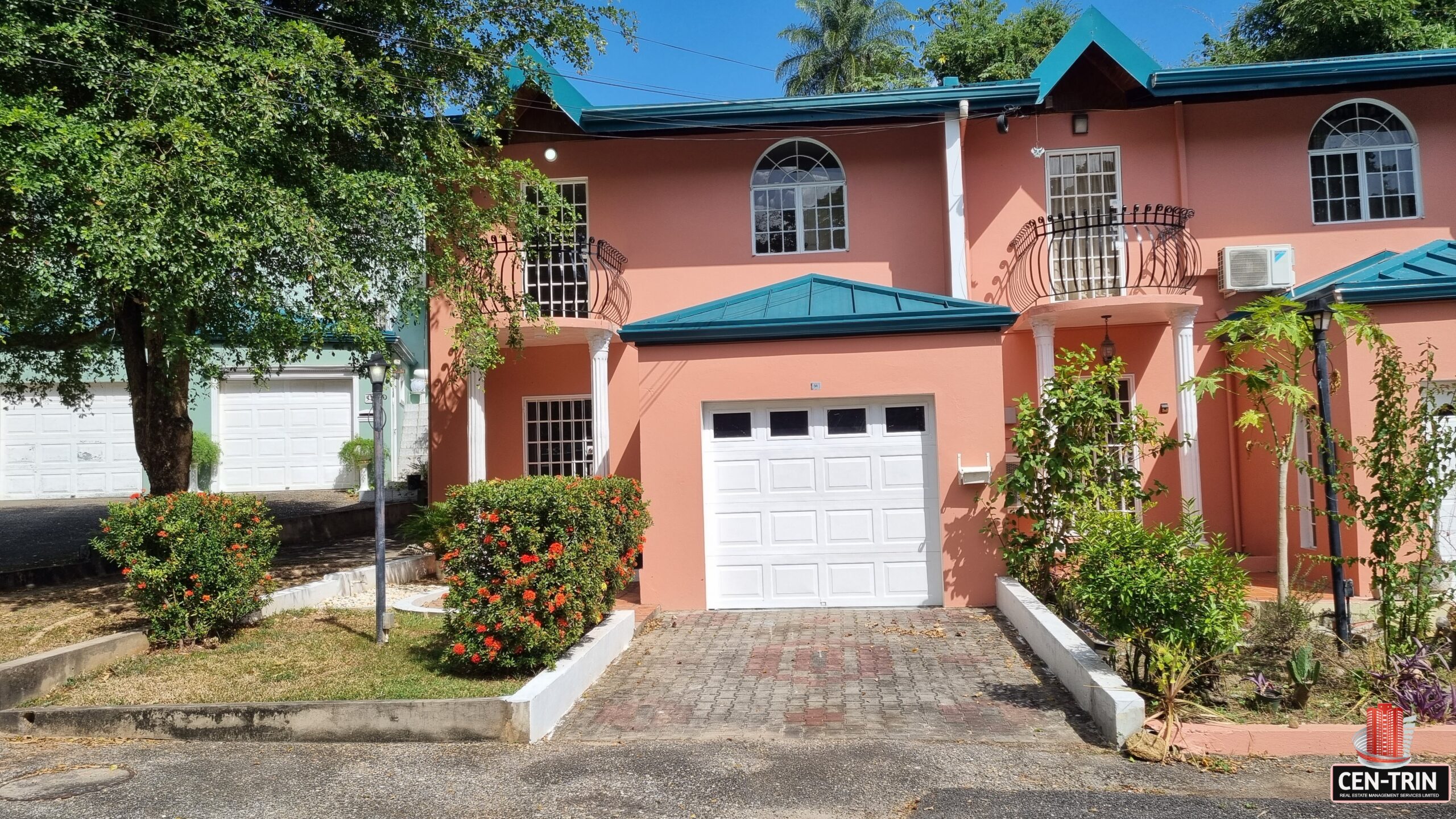 A pink three-bedroom townhouse with a white garage door.