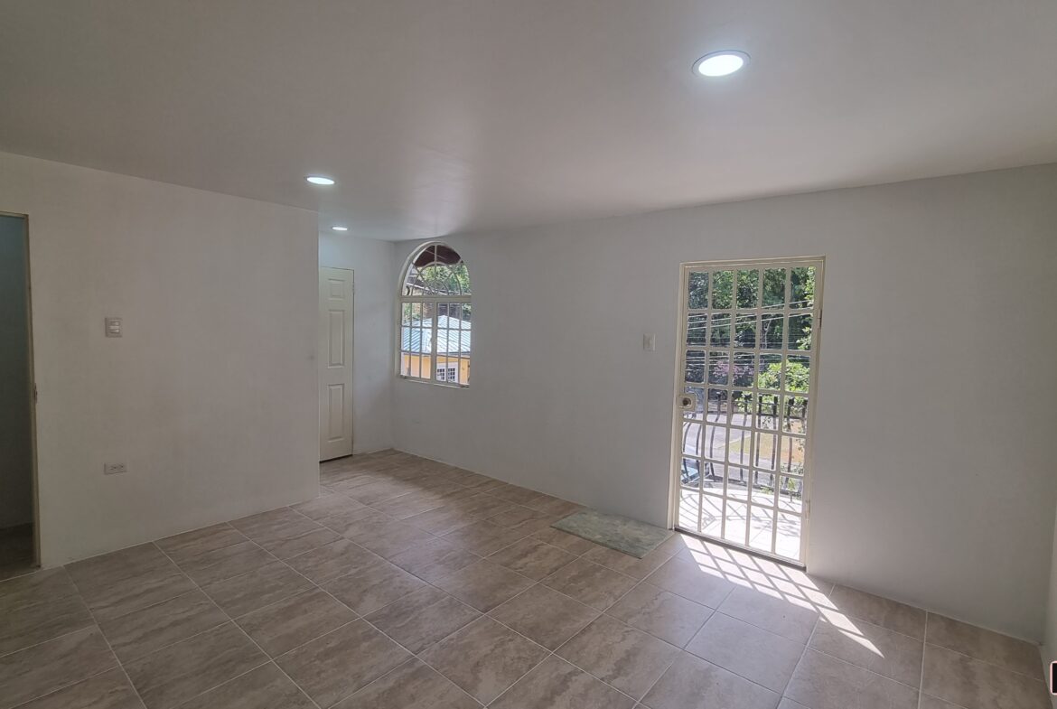 Master bedroom with mirrored closet doors and window with blinds in a 3 bedroom townhouse rental.