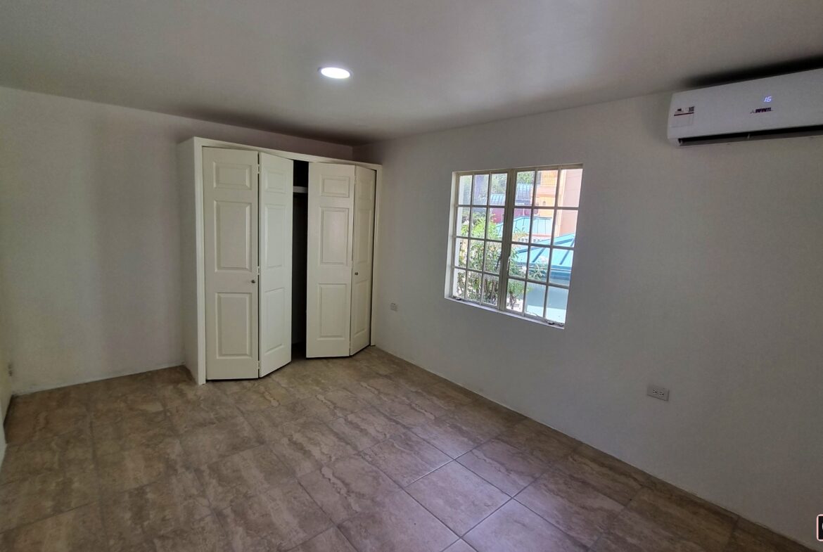Bedroom with closet, window, and twin bed space in a 3 bedroom townhouse rental.