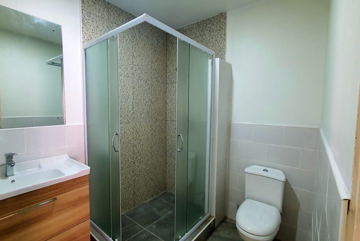 Shower with a glass enclosure, stainless steel showerhead, and tile surround in a 3 bedroom townhouse rental.