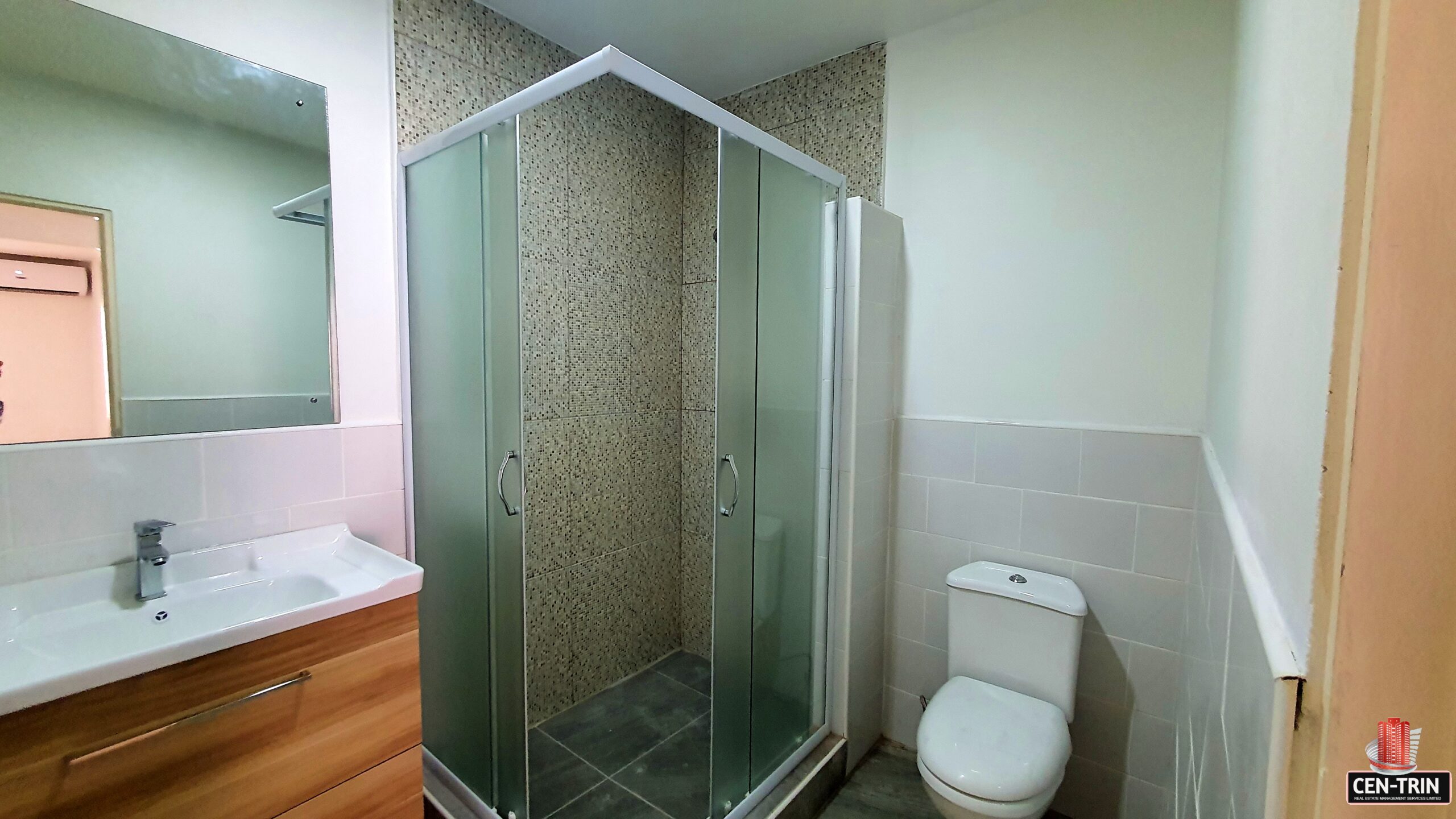 Shower with a glass enclosure, stainless steel showerhead, and tile surround in a 3 bedroom townhouse rental.