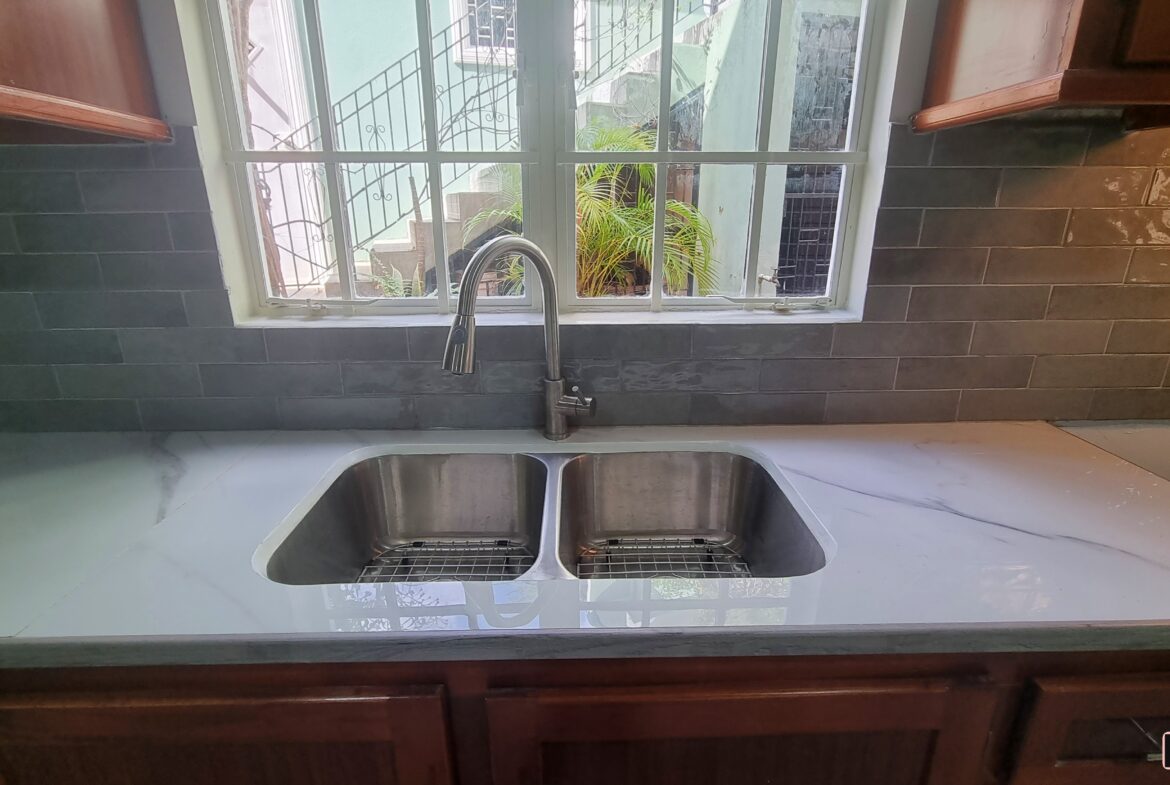 Double sink and window in kitchen of a 3 bedroom townhouse rental.
