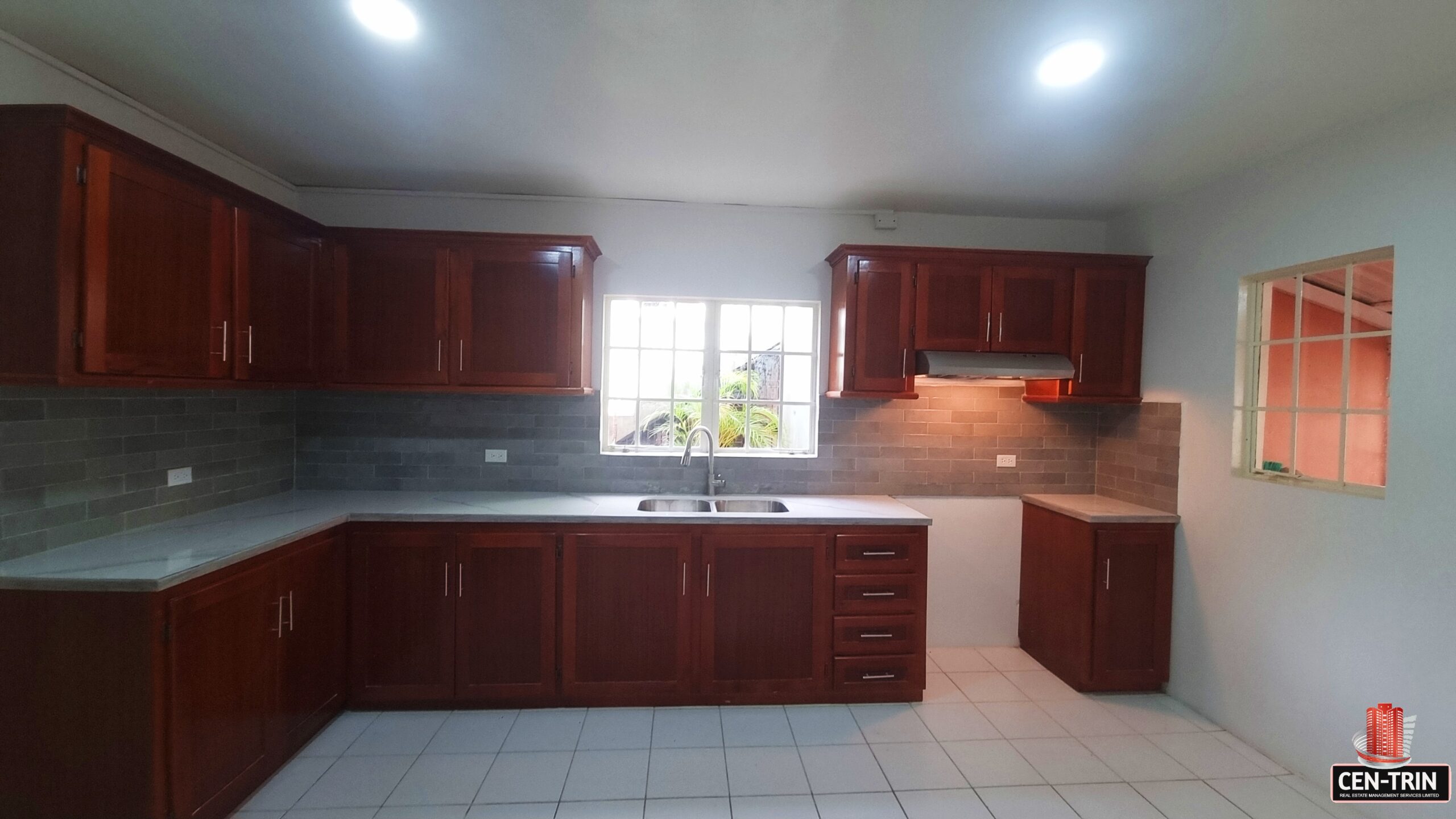 Kitchen with sink, cabinets, and window in a 3 bedroom townhouse rental.
