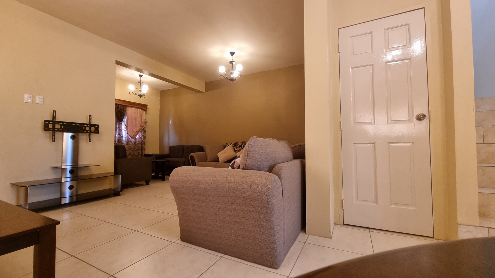 Living room area in townhouse for sale with couch, coffee table, and TV.