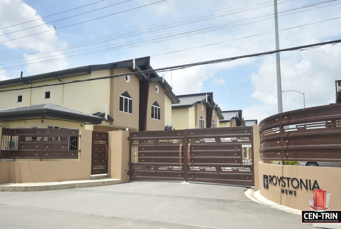 A row of modern townhomes with balconies and driveways.