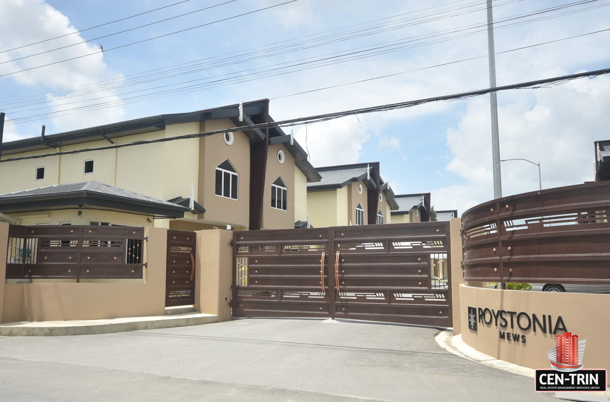 A row of modern townhomes with balconies and driveways.