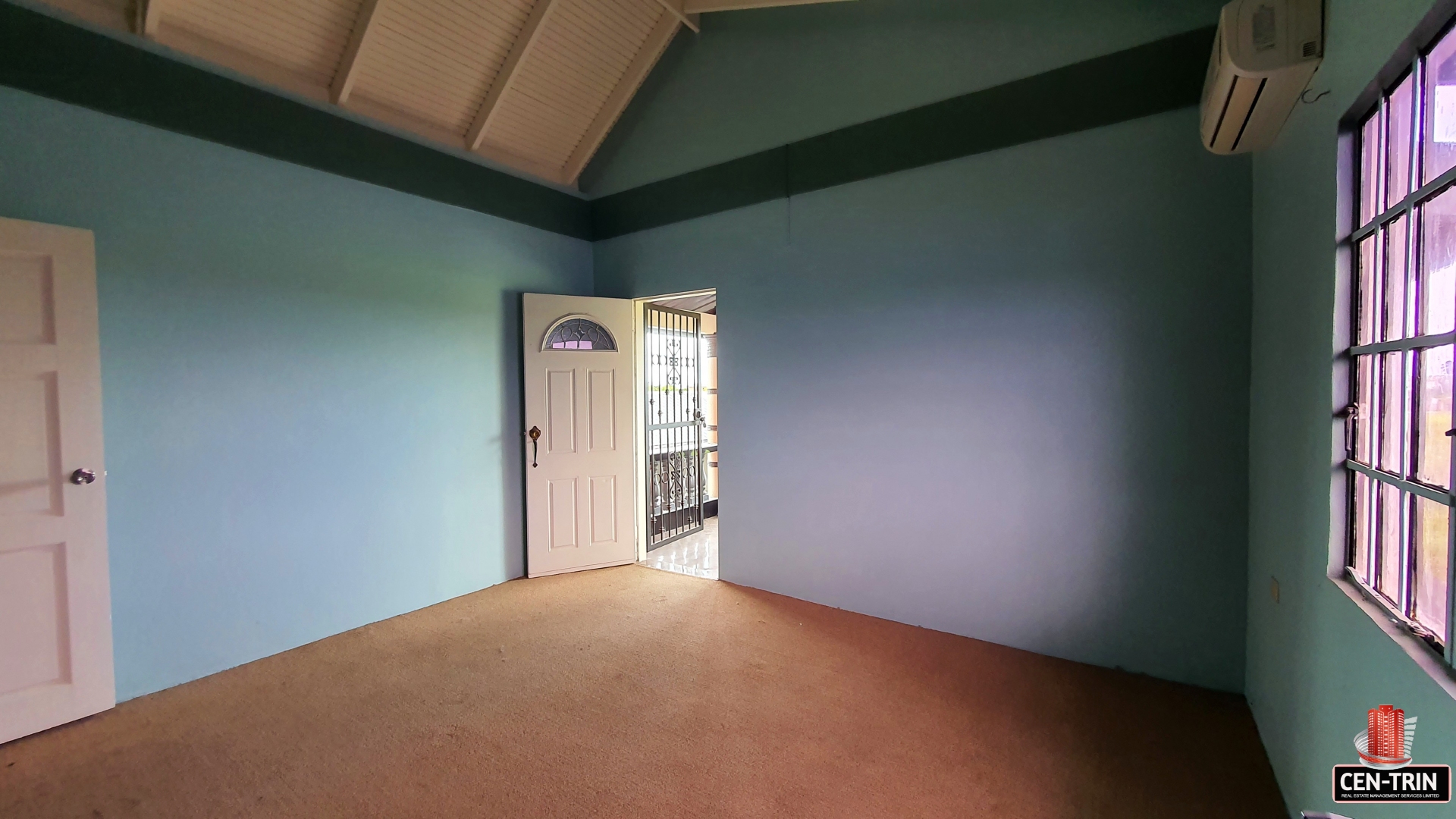 An empty room with a closed door and windows.