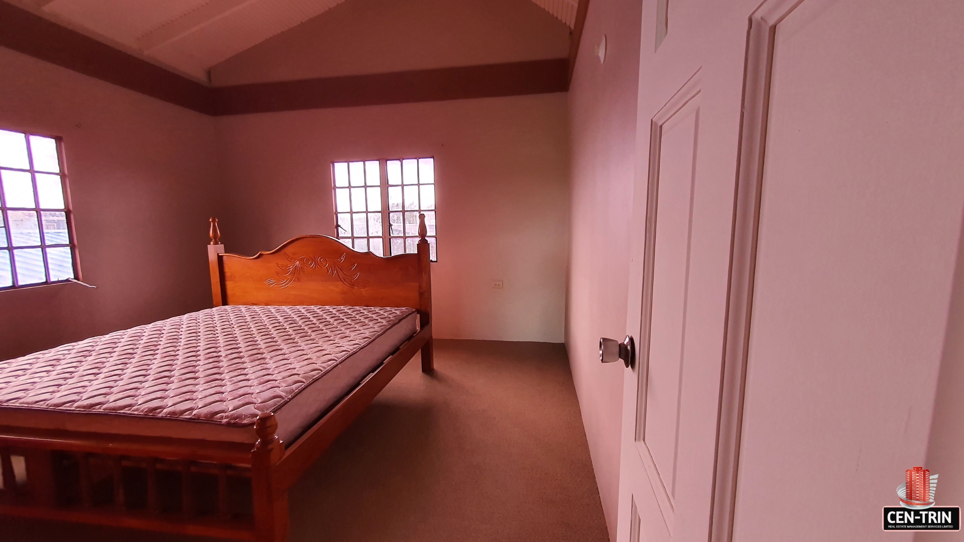 A charming bedroom with a teak king-size cot, a window