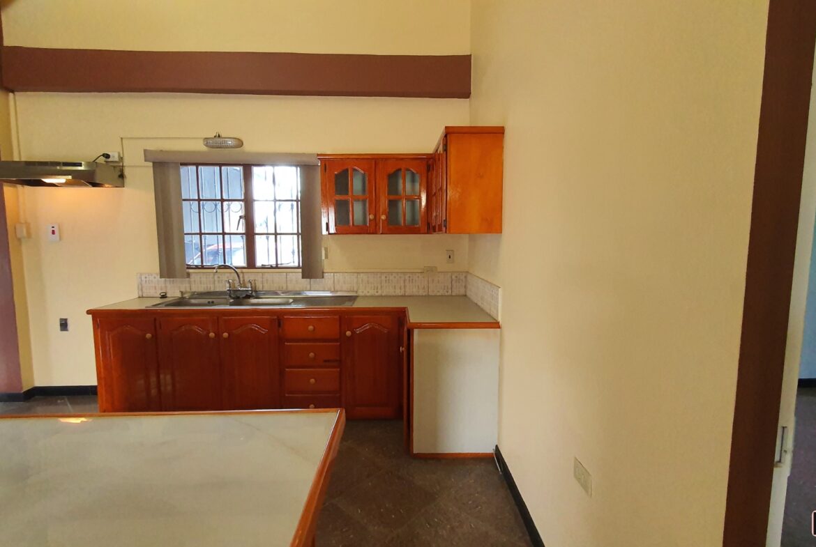 A charming kitchen with wooden cabinets and a sink with a faucet.