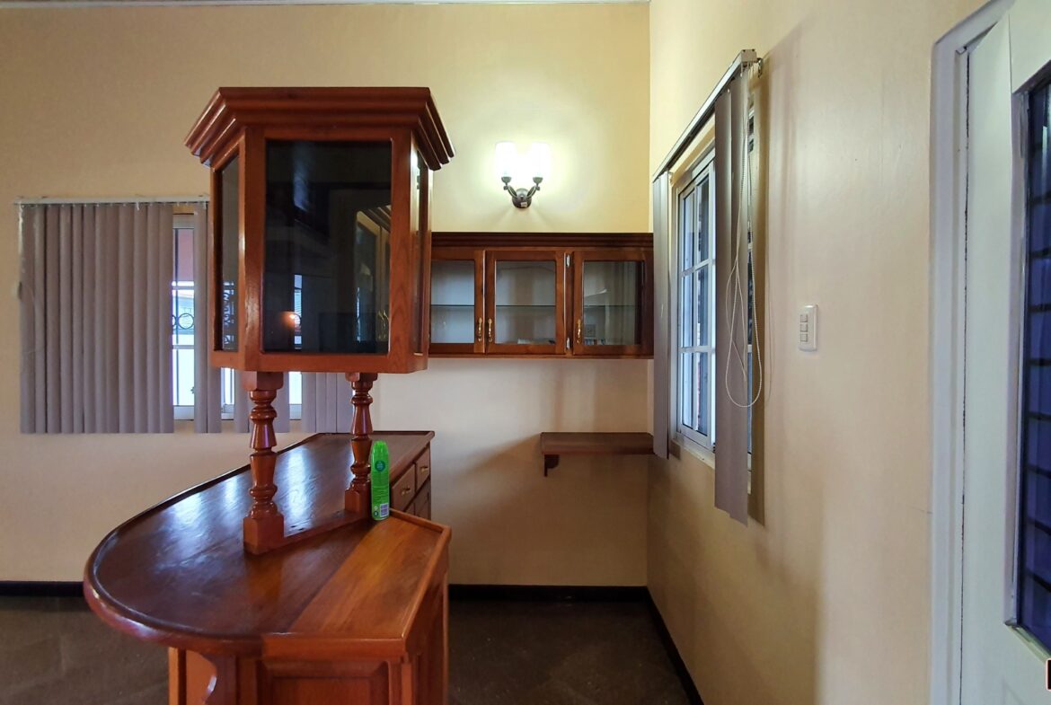 A charming kitchen with a breakfast bar, cabinets and a window