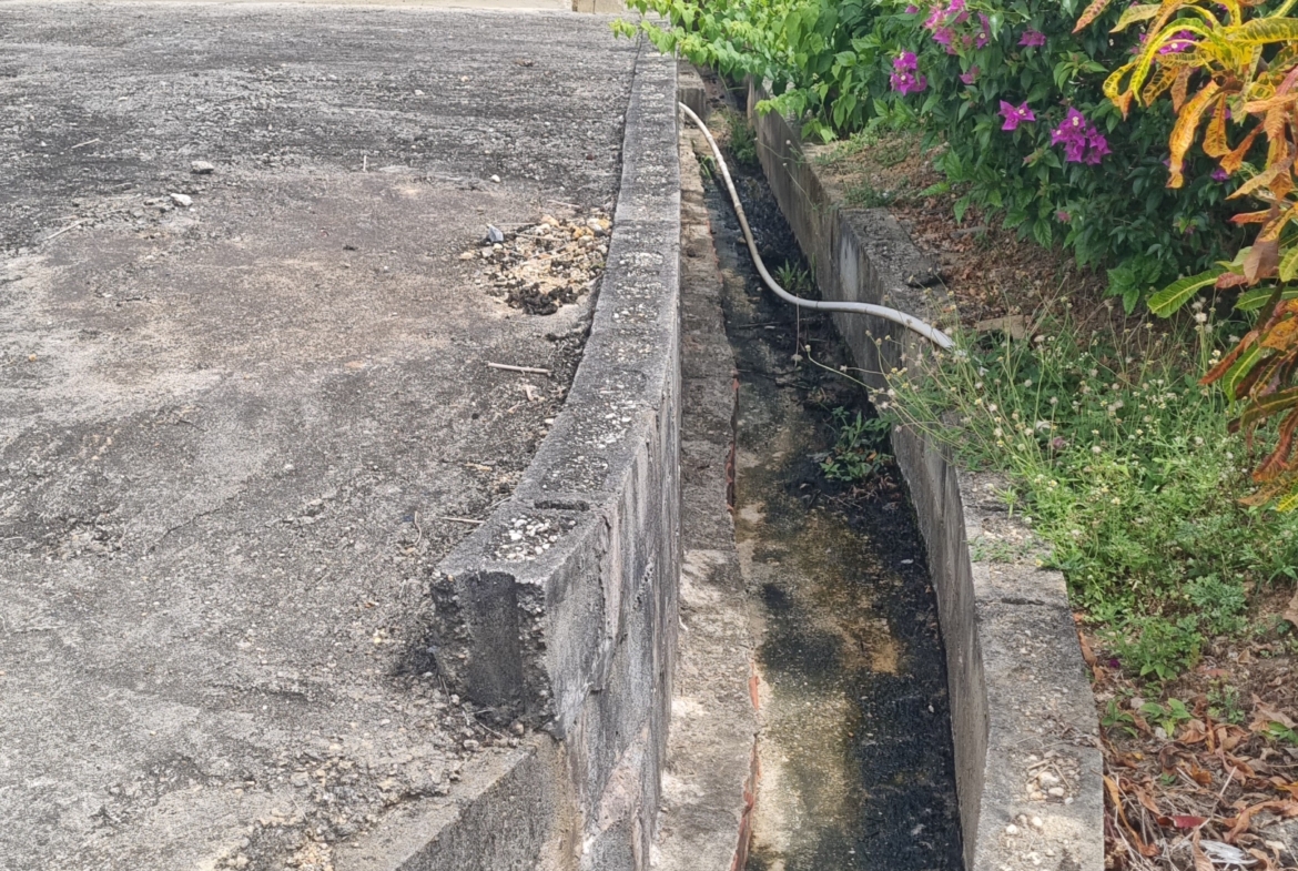 Las Lomas #1 2 Bedroom House For Sale - Front Drain Leading To main Road