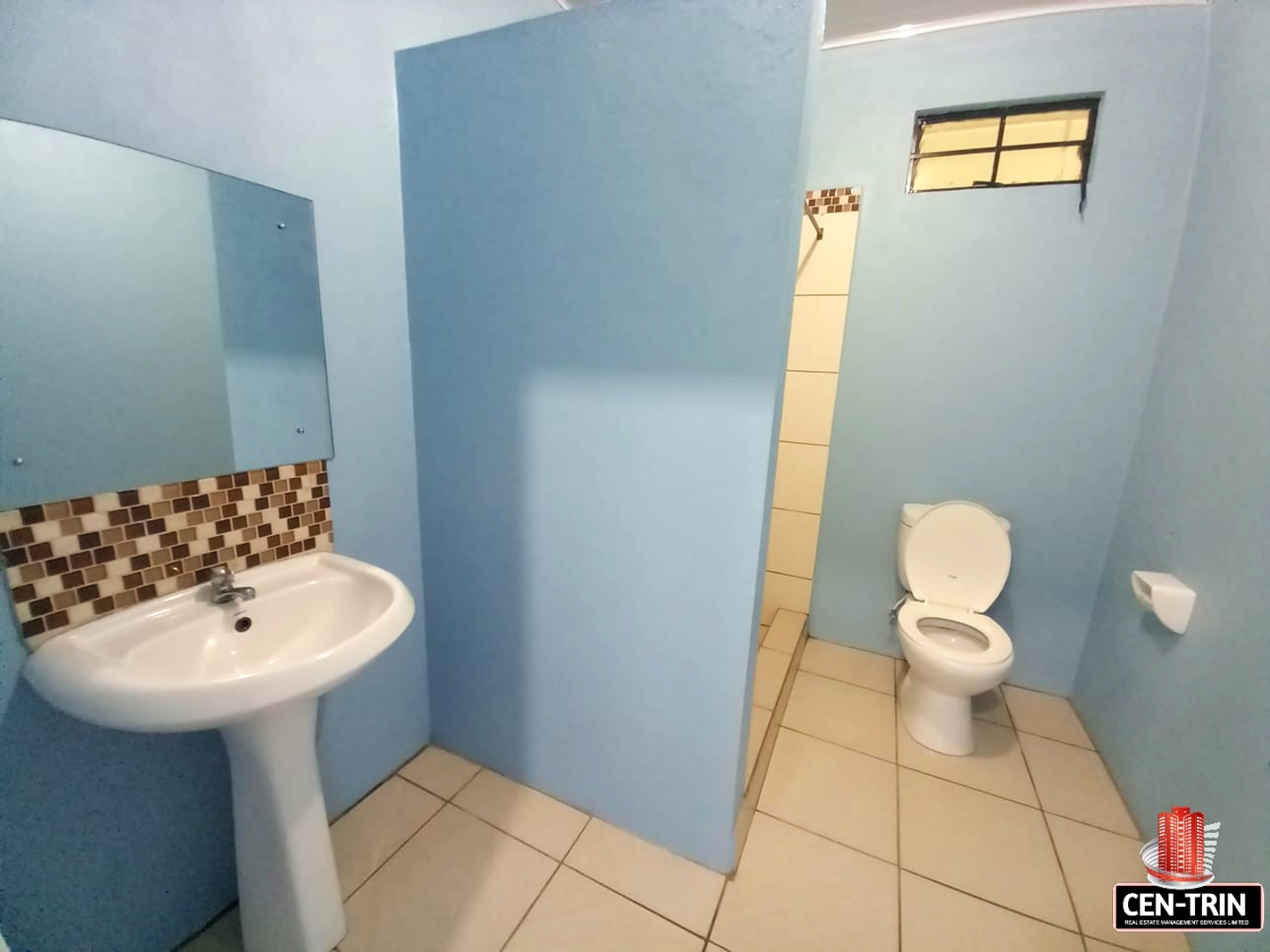 Bathroom with a white sink, toilet, and mirror.