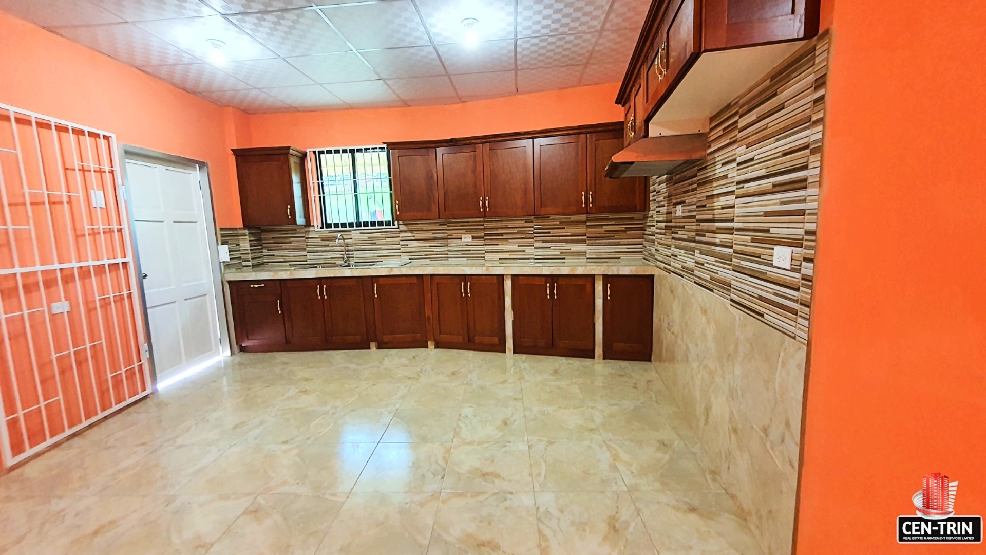Close-up of a kitchen sink with faucet and stainless steel sprayer in a kitchen with wooden cabinets.