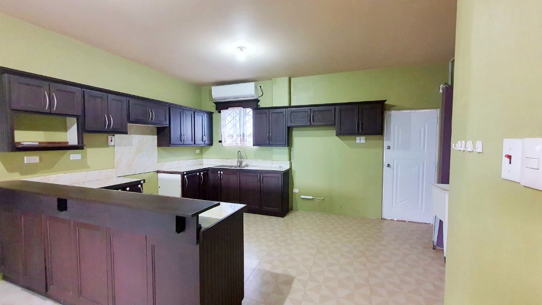 Spacious living area with comfortable furniture in Chaguanas gated apartment (Cen-Trin Real Estate)