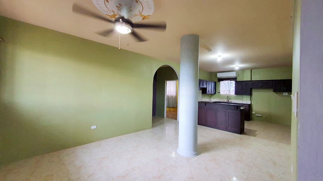 Spacious living area with comfortable furniture in Chaguanas gated apartment (Cen-Trin Real Estate)