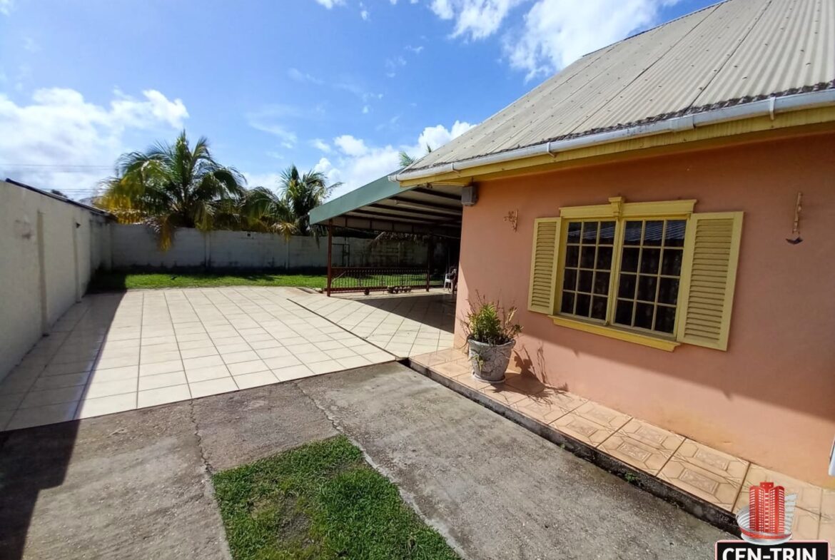 A pink house with a large grassy backyard for sale.