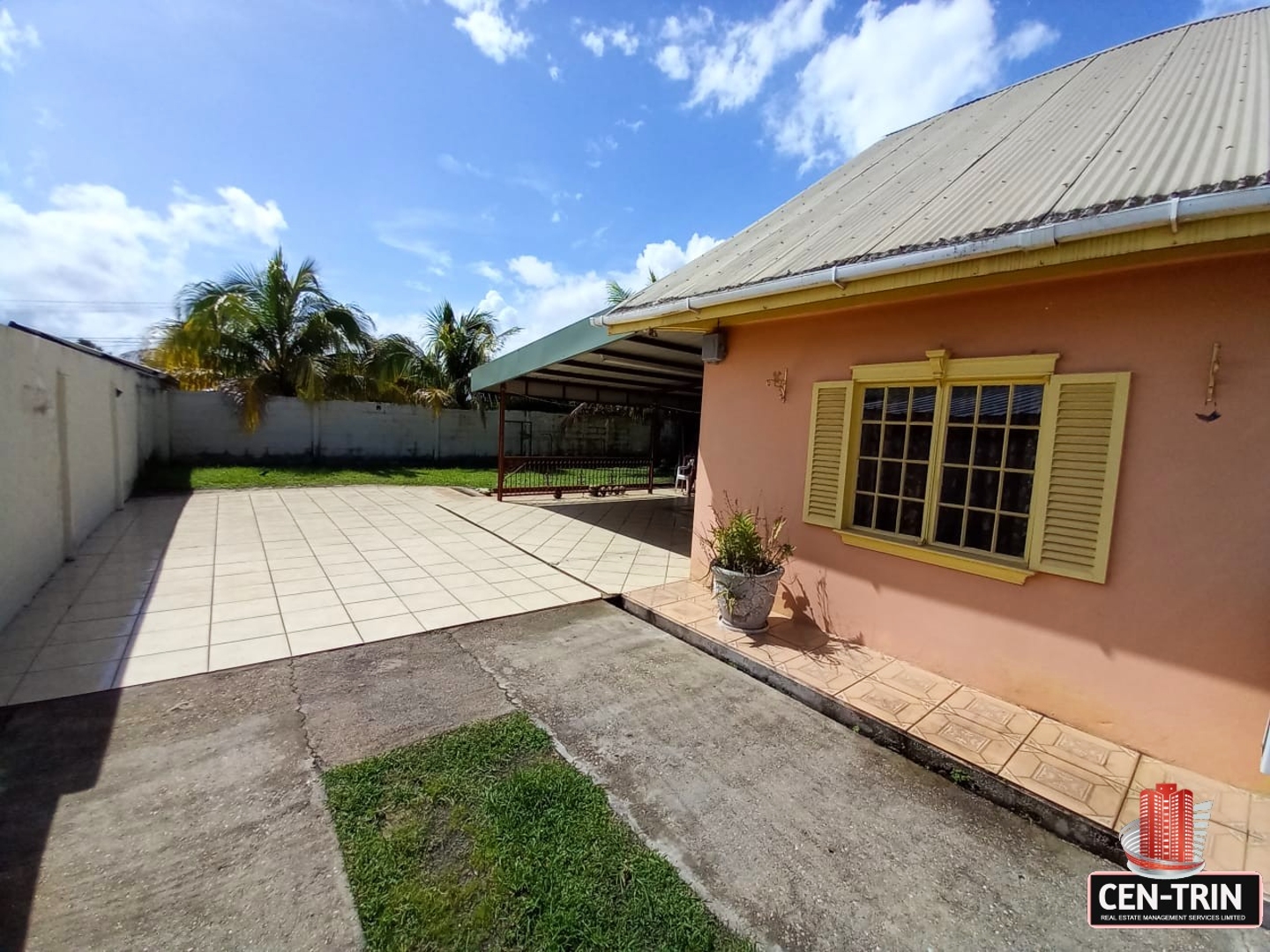 A pink house with a large grassy backyard for sale.