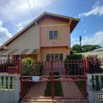The front of a 3-Bedroom House for Sale with a red gate