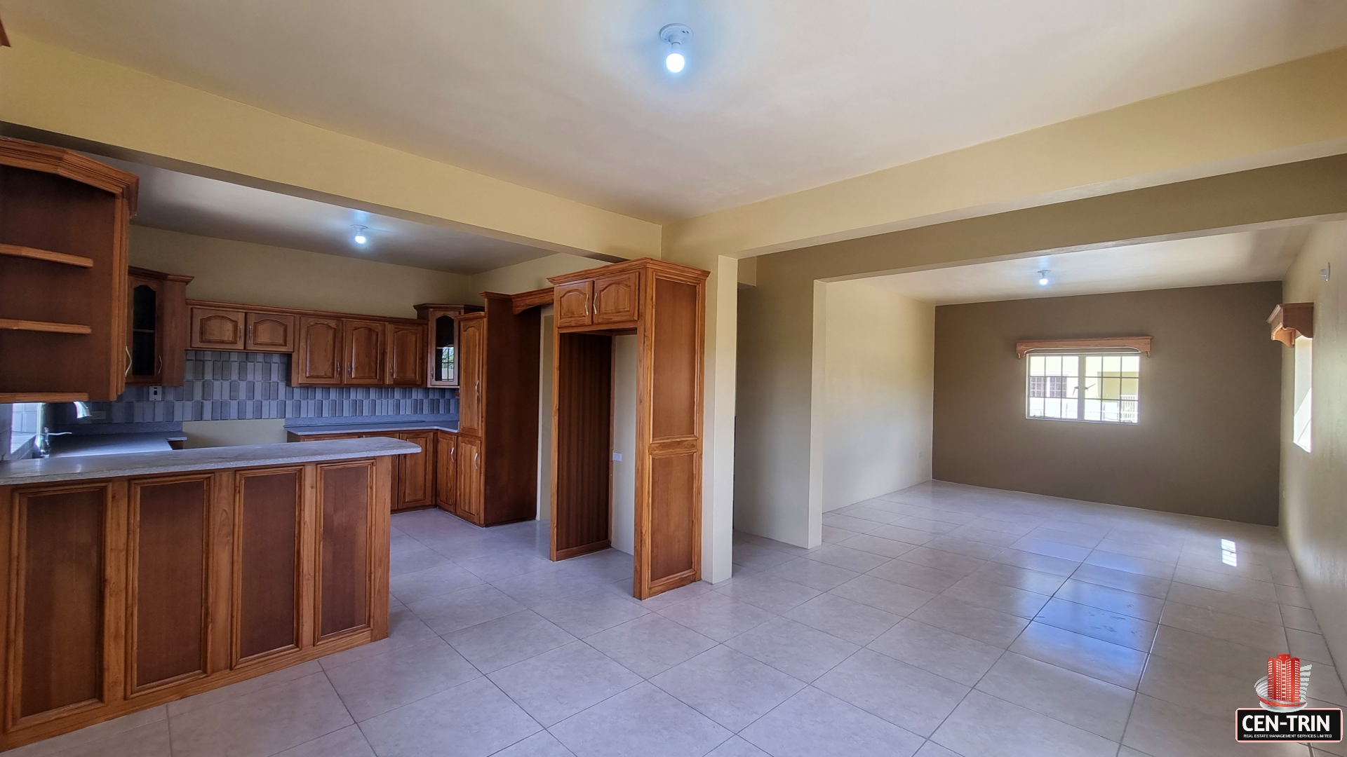 Open concept living and kitchen area in townhouse for sale. The kitchen has stainless steel appliances, granite countertops, and a breakfast bar.