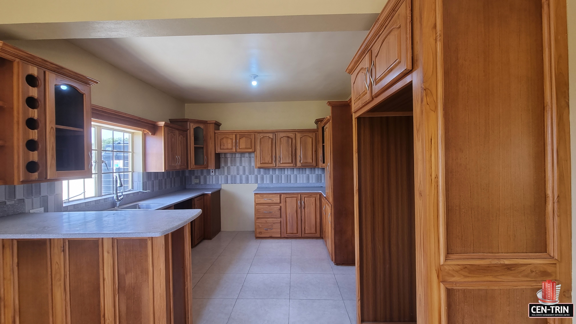 Kitchen area in townhouse for sale with wooden cabinets, sink, faucet, and stainless steel dishwasher.