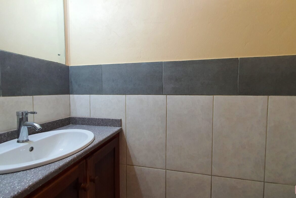 Bathroom sink with faucet and mirror in townhouse for sale.