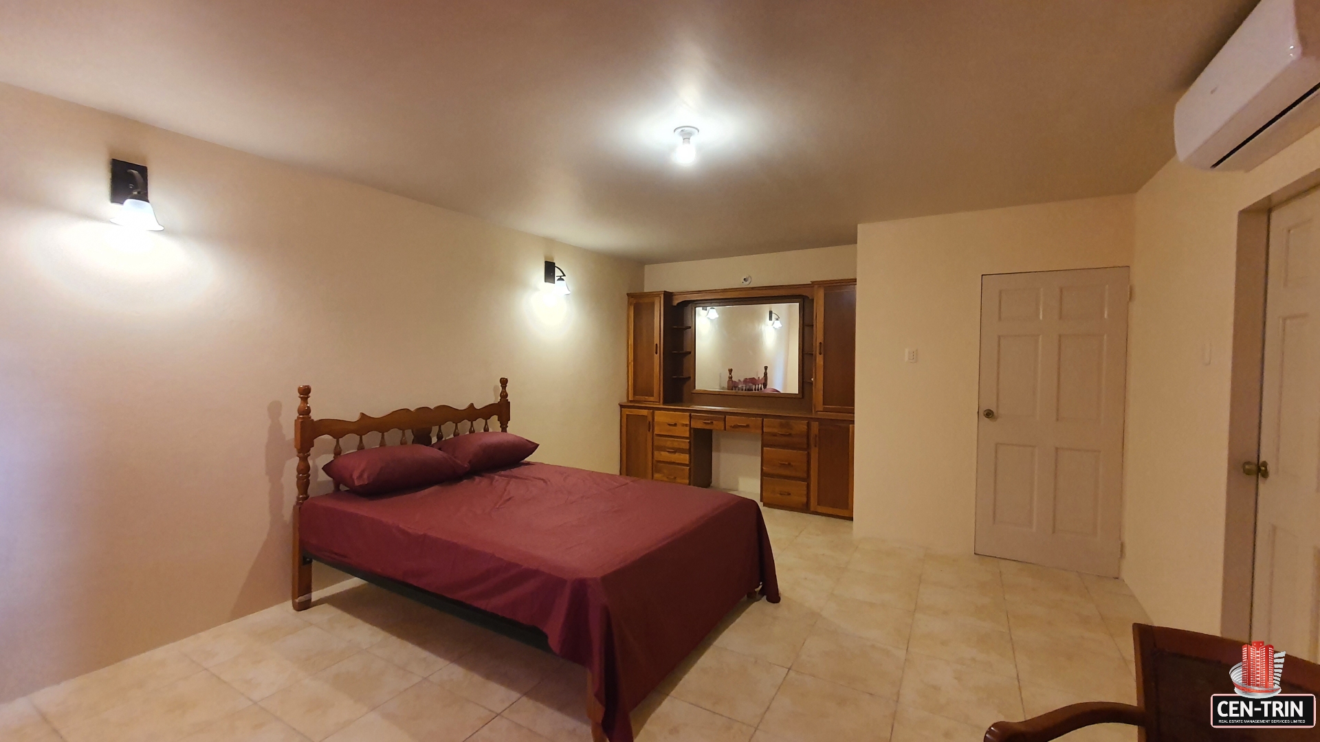 Master bedroom in townhouse for sale with bed, dresser, and mirror.