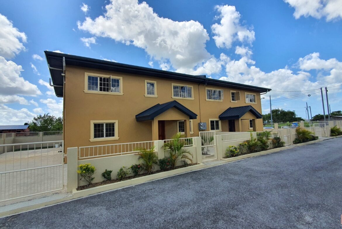 Yellow two-story townhouse with blue sky.