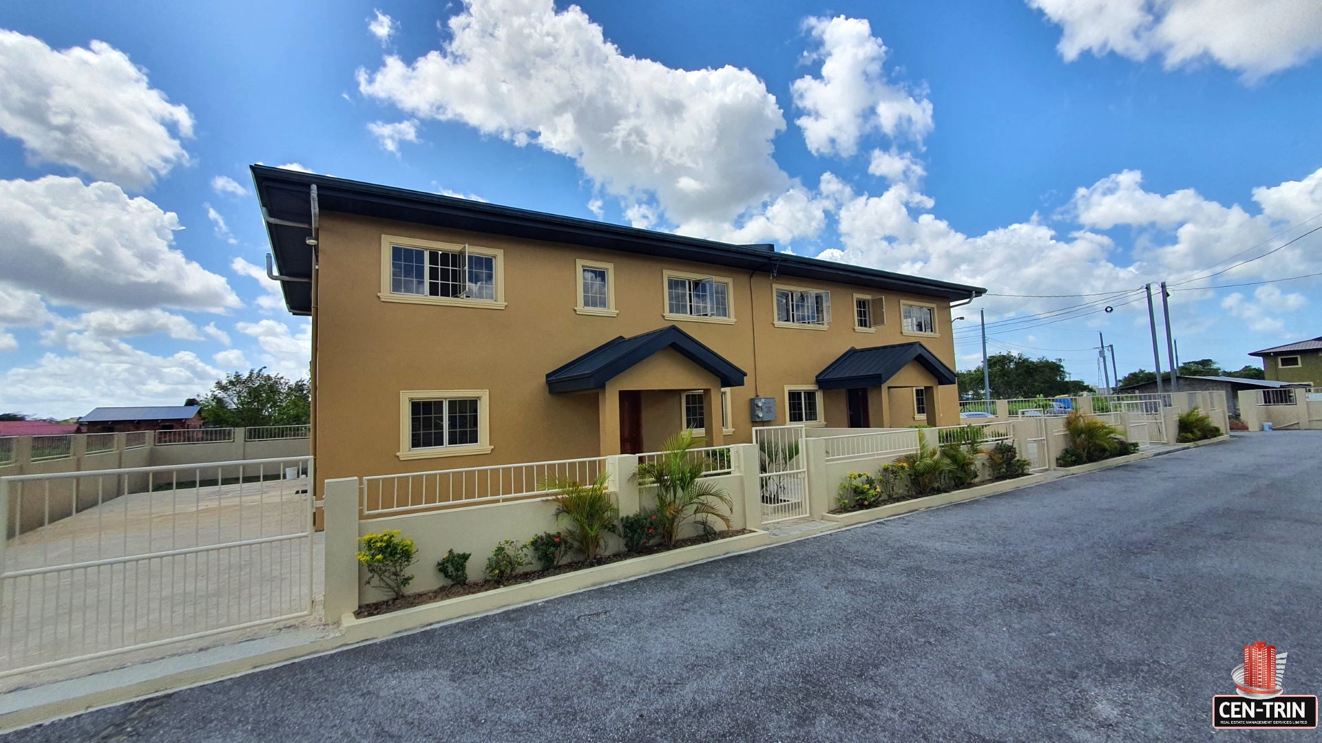 Yellow two-story townhouse with blue sky.
