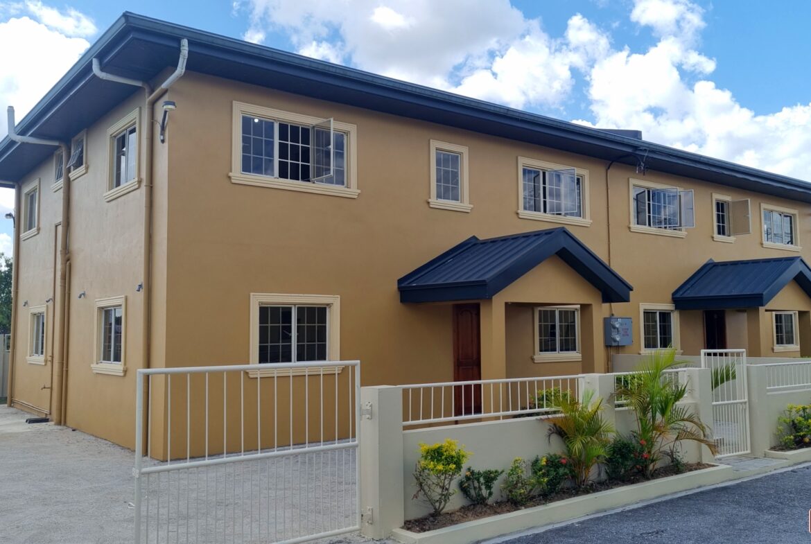 Townhouse for sale with fence and multiple windows.
