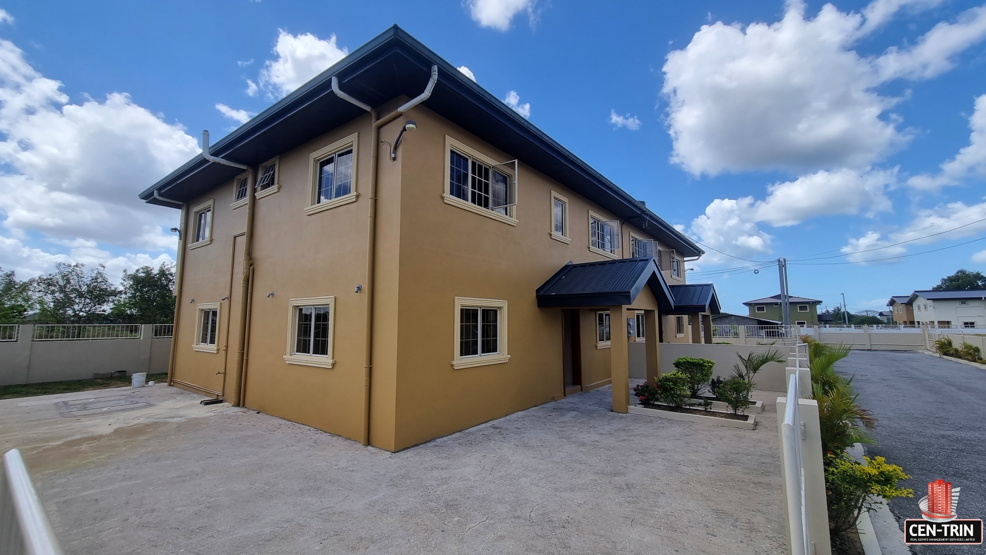 Large yellow townhouse with many windows for sale in a rural area.
