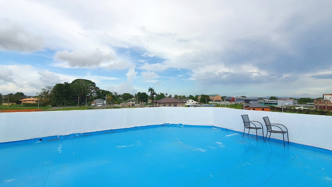 Spacious living area with comfortable furniture in Chaguanas gated apartment (Cen-Trin Real Estate)