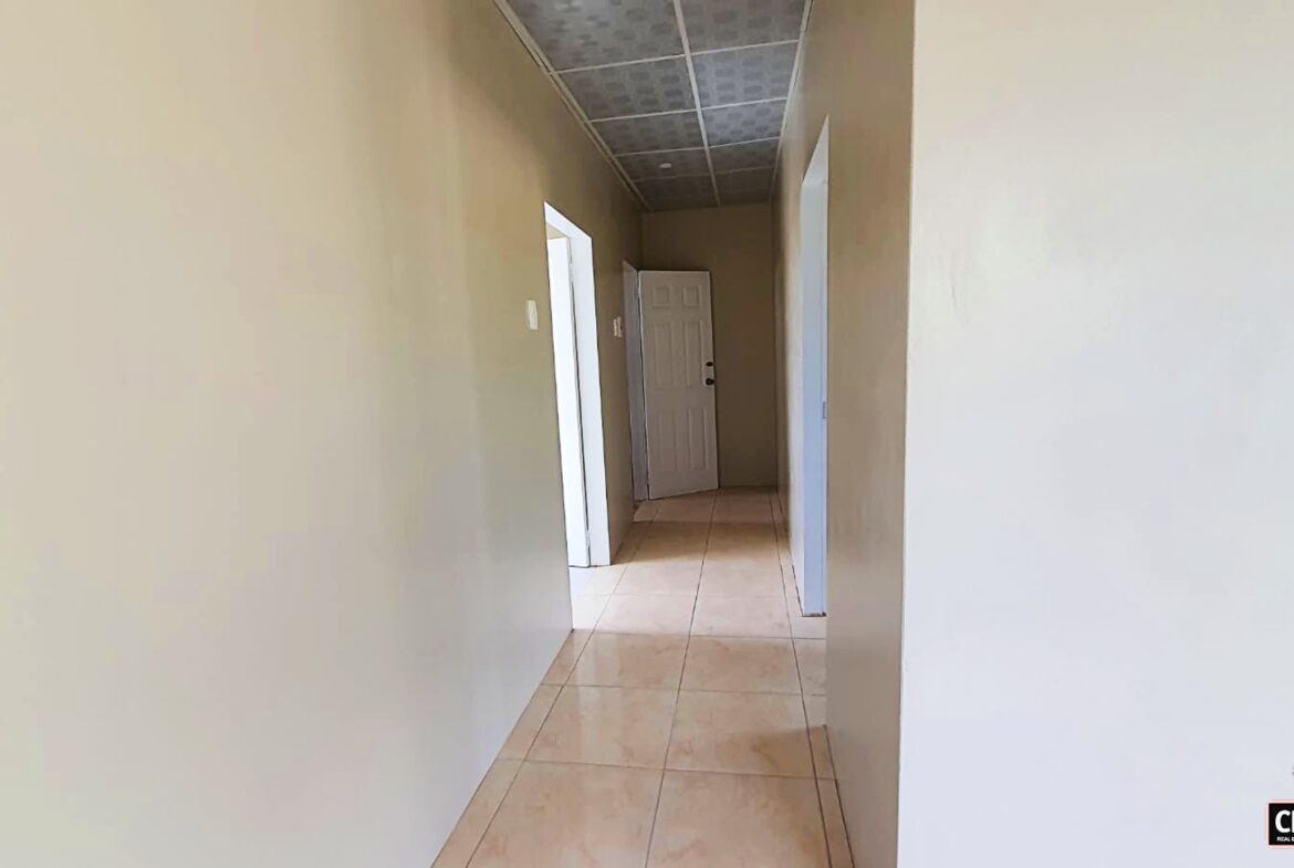Interior hallway with closed door and tiled floor