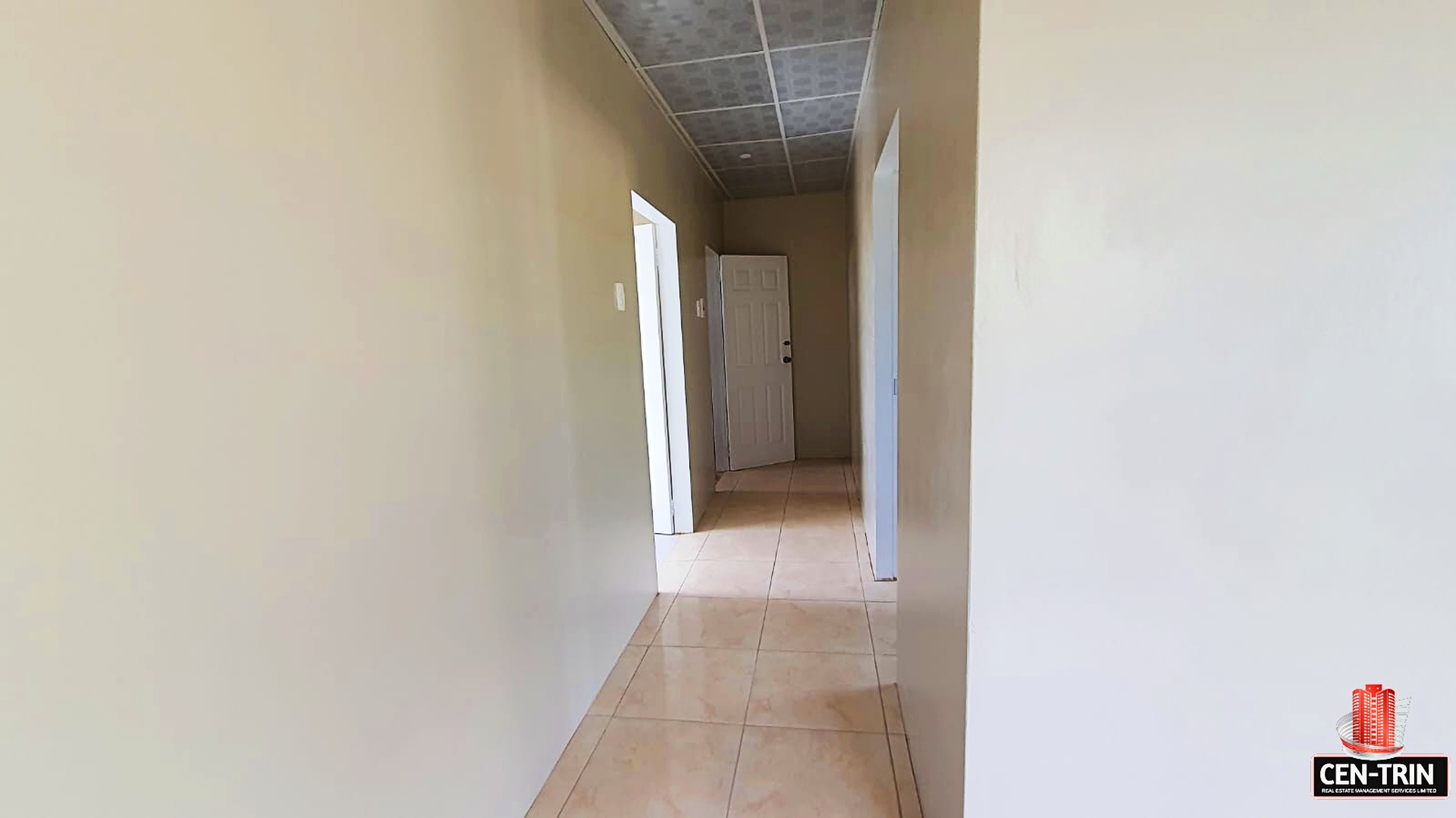 Interior hallway with closed door and tiled floor