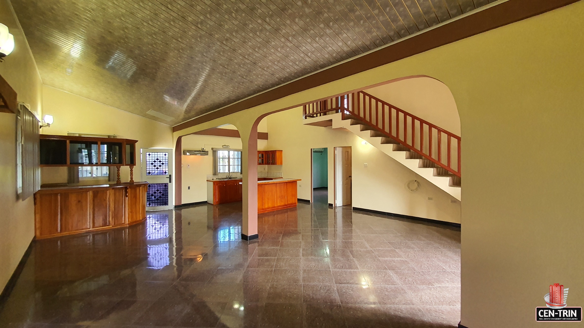 A charming room interior with a grand staircase leading to a second floor landing.
