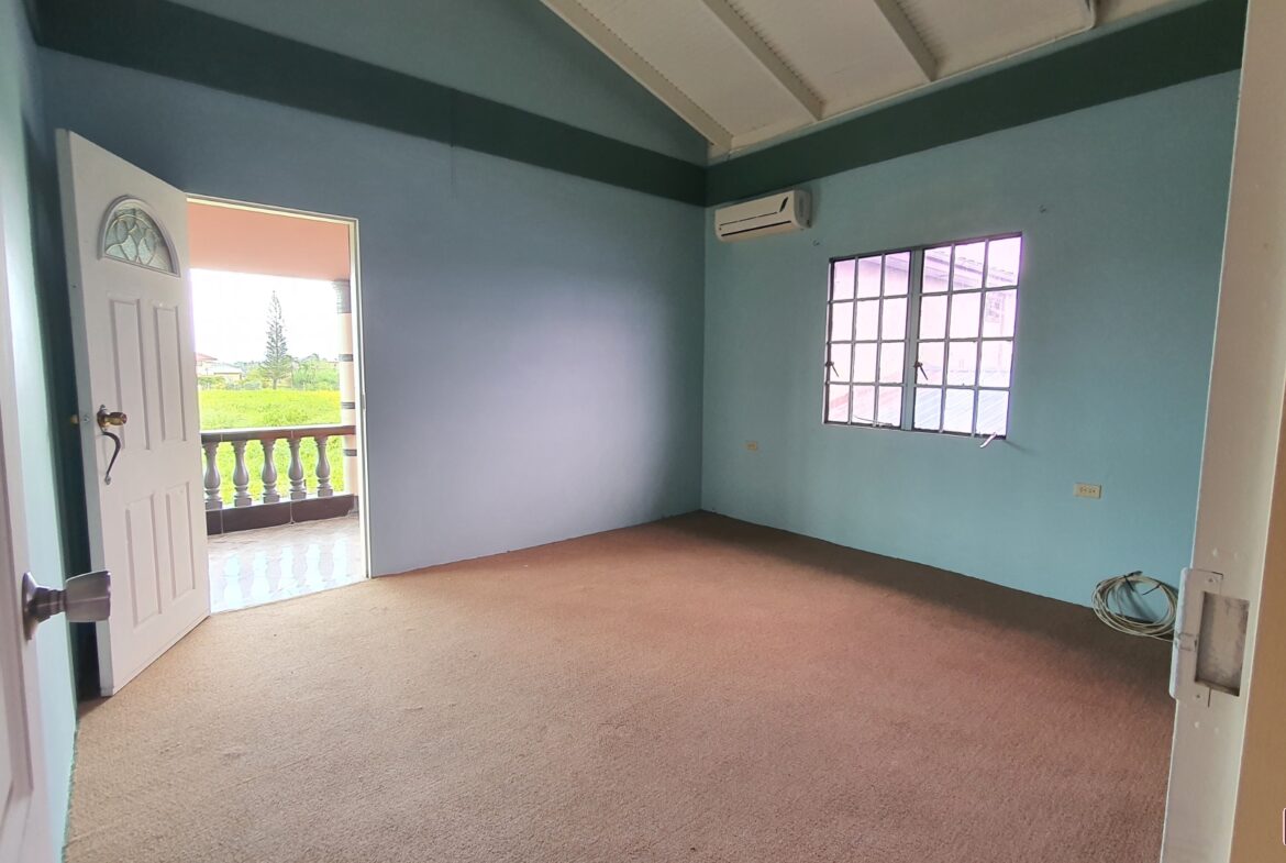 A charming room with a wooden door and a window with a white curtain.